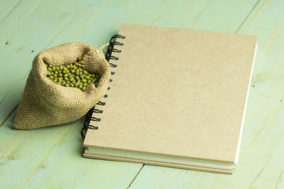 High angle view of mung beans by spiral notebook on table