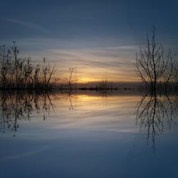 Scenic view of lake against sky at sunset