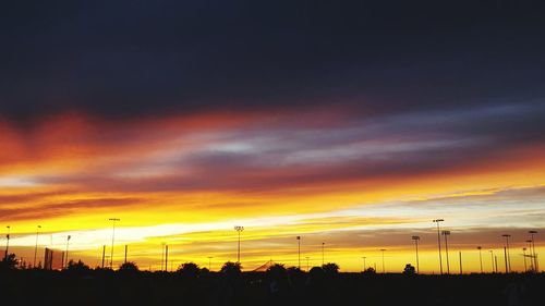 Silhouette landscape against dramatic sky during sunset