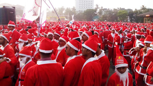 Crowd in santa claus costumes during parade in city