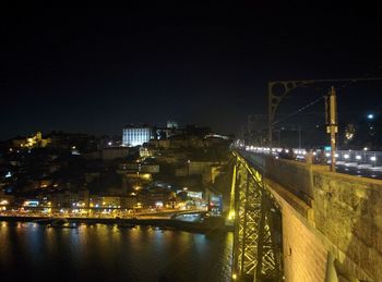 Illuminated bridge in city against sky at night