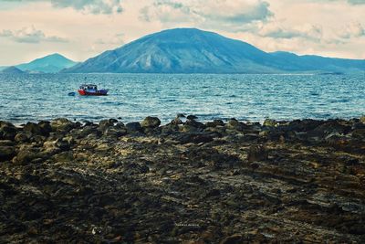 Scenic view of sea and mountains against sky