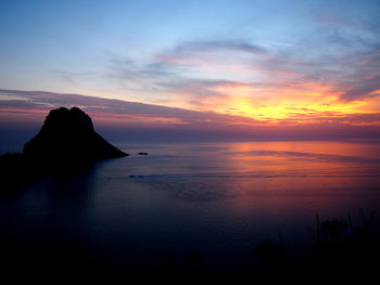 Scenic view of sea against dramatic sky during sunset