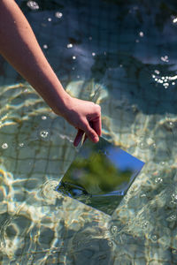 Close-up of woman holding metal in pool