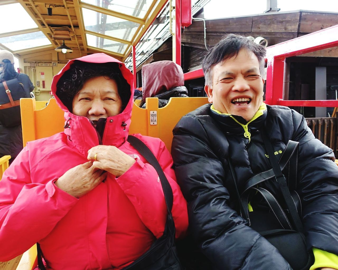 Couple wearing warm clothing sitting in bus