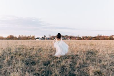 Rear view of woman standing on field