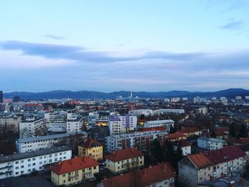 Buildings in town against cloudy sky