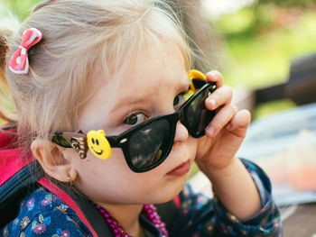 Close-up portrait of cute girl wearing sunglasses