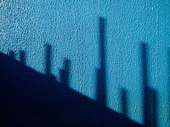 Shadow of construction rods on blue wall