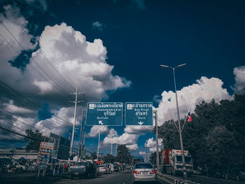 Cars on street in city against sky