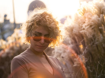 Portrait of young woman wearing sunglasses standing outdoors