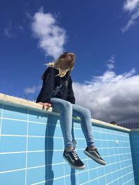 Low angle view of woman against blue sky