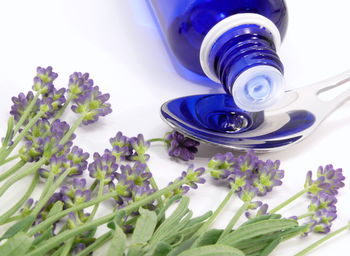 Close-up of bottle with spoon and flowers on table