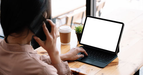 Midsection of woman using laptop on table
