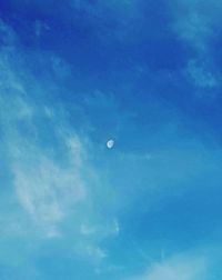 Low angle view of moon against blue sky