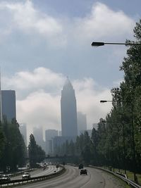 Cars on road in city against sky