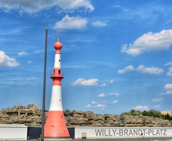 Lighthouse amidst buildings against sky