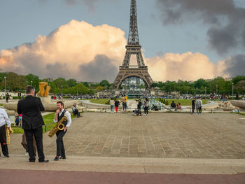 People at town square against cloudy sky