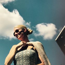 Low angle view of woman wearing sunglasses against sky
