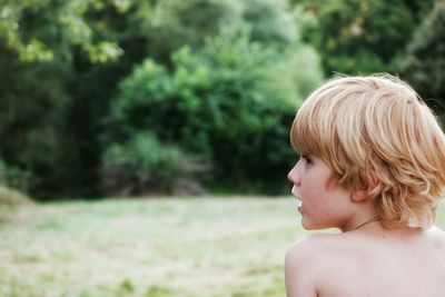 Rear view of shirtless boy in park