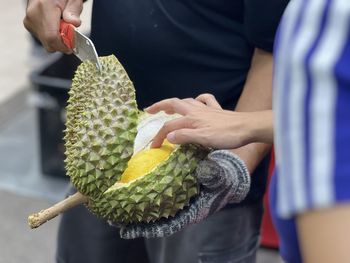 Midsection of man holding pineapple
