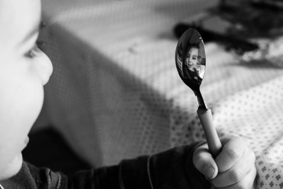 Baby boy holding spoon at table