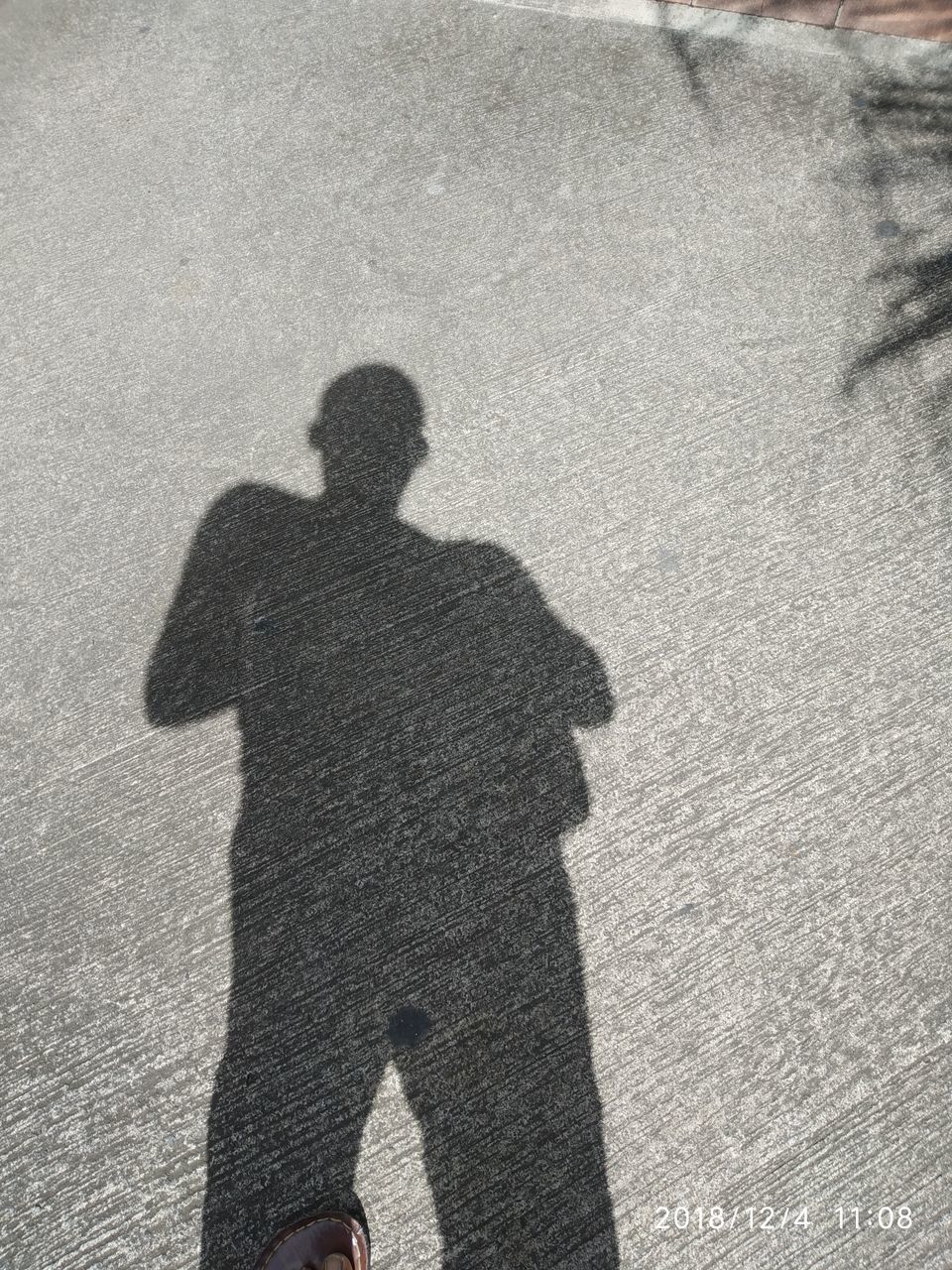 SHADOW OF PERSON ON ROAD