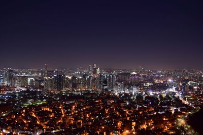 Illuminated city against sky at night