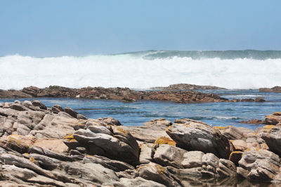 Scenic view of rocks on beach against sky