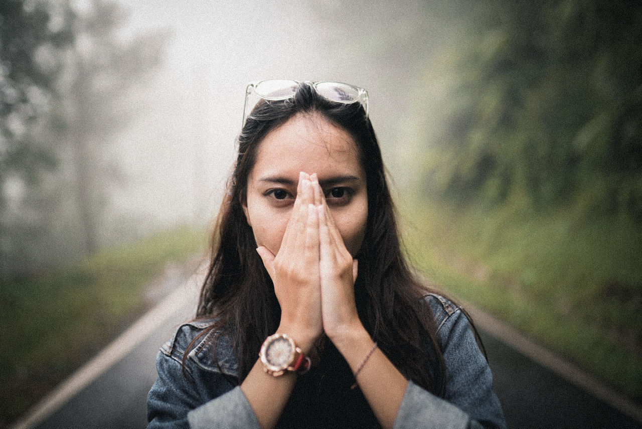 PORTRAIT OF BEAUTIFUL YOUNG WOMAN WITH ROAD