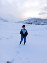 Full length of man standing on snow against sky