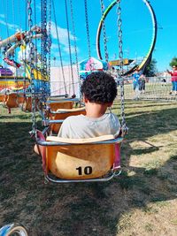 Boy on a chain swing at the county fair