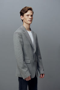 Portrait of young man standing against wall