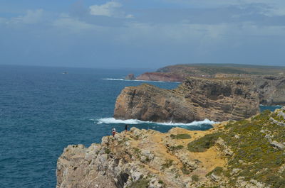 Rock formation by sea against sky