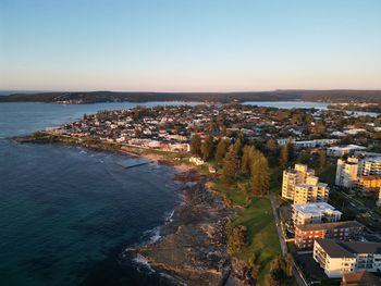 High angle view of townscape by sea against clear sky