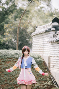 Portrait of a smiling girl standing against trees