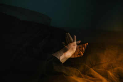 Double exposure image of textile and hands at night