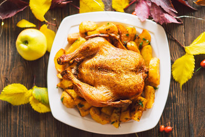 Autumn composition with leaves, ripe pumpkin and thanksgiving turkey on a dark wooden table.