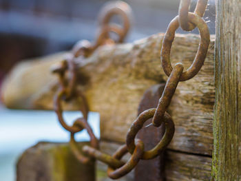 Close-up of rusty chain on wooden door