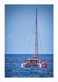 Boat sailing in sea against clear blue sky
