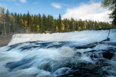 Scenic view of waterfall against sky