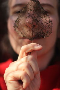 Close-up of hand holding dry leaf. leaf skeleton