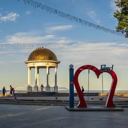 People in front of historical building against cloudy sky