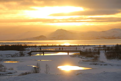 Scenic view of snowcapped mountains against sky during sunset