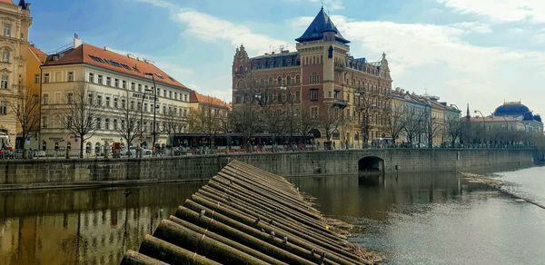 Bridge over river against buildings in city