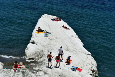 High angle view of people on rock by sea