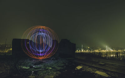 Illuminated light trail against sky at night