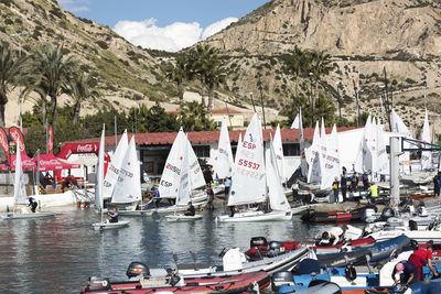 Panoramic view of people on sailboat against mountain