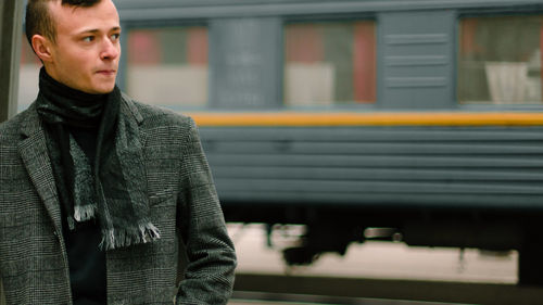 Young man standing at railroad station