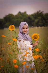 Portrait of smiling woman standing on field